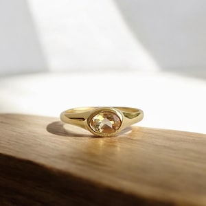 Peut inclure: Une bague en or avec une pierre précieuse ronde de couleur jaune clair sertie dans une monture à sertir.