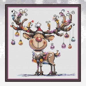 Könnte beinhalten: Ein Kreuzstich-Design eines Cartoon-Rentiers mit Weihnachtsmütze und geschmückt mit Ornamenten. Das Rentier hat ein großes Lächeln und ist mit bunten Kugeln auf seinem Geweih und um seinen Hals geschmückt, perfekt für Weihnachten.