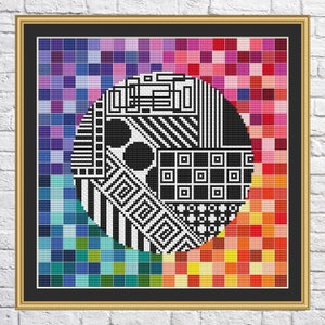 May include: A black and white geometric pattern inside a circle, surrounded by a colorful grid of squares in shades of purple, blue, green, yellow, orange, and red.