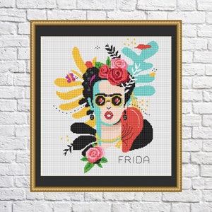 May include: A colorful cross-stitch pattern featuring Frida Kahlo with flowers in her hair, sunglasses, and a red heart. The background is a mix of abstract shapes and colors. The text "FRIDA" is written below the image.