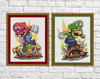 May include: Two framed cross-stitch pictures of Mario and Luigi characters from the Super Mario Bros. video game series. The pictures are set against a white brick wall.