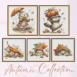 May include: Five framed cross-stitch artworks depicting autumnal scenes with animals. A duck with an umbrella, a raccoon with a pumpkin, a sleeping deer, a rabbit, and a hedgehog are shown with leaves and pumpkins. The text "Autumn Collection" is at the bottom.