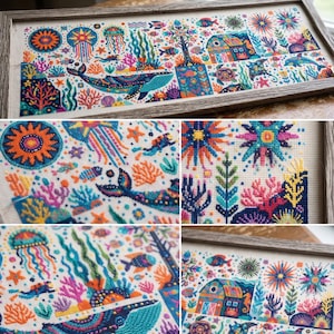 May include: A rectangular cross-stitch embroidery in a wooden frame featuring a vibrant underwater scene. The design includes a large blue whale, jellyfish, coral reefs, sea creatures, a scuba diver, and a small house, all rendered in bright, multicolored thread on a light fabric background.