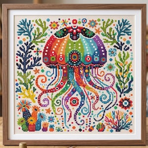 May include: A framed cross-stitch embroidery featuring a vibrant, multi-coloured jellyfish as the central subject. The jellyfish is surrounded by various aquatic plants, coral formations, and small geometric floral patterns in a rainbow colour palette.