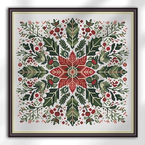 Puede incluir: Punto de cruz enmarcado con un diseño floral simétrico. El motivo central es una flor de pascua roja, rodeada de hojas verdes y bayas rojas. La obra de arte está sobre un fondo blanco y enmarcada en un marco marrón oscuro.
