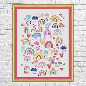 May include: A colorful cross-stitch pattern featuring a variety of rainbows, hearts, clouds, and suns. The pattern is framed in a gold frame with a pink mat.