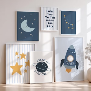 Puede incluir: Una colección de láminas artísticas enmarcadas con temática espacial. Las láminas presentan una luna creciente, constelaciones, un cohete con el nombre "Oliver", estrellas y las frases "Love You to the Moon and Back" y "Dream Big Little One".