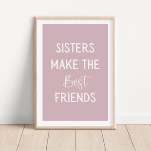 May include: A framed print with a pink background and white text that reads "Sisters make the best friends".