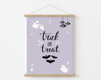 May include: A lavender-colored printable sign with the text "trick or treat" in black script font. The sign is decorated with white ghosts, black bats, and black spiders.