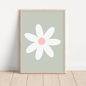 May include: A framed print of a white daisy with a pink center on a sage green background.