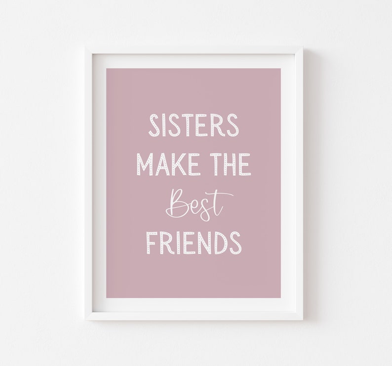 May include: A dusty rose pink printable wall art print with white text that reads "Sisters make the best friends".