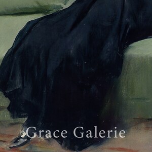 May include: A close-up of a black dress with a long skirt, the fabric is draped over a green couch. The text "Grace Galerie" is visible in the bottom right corner of the image.
