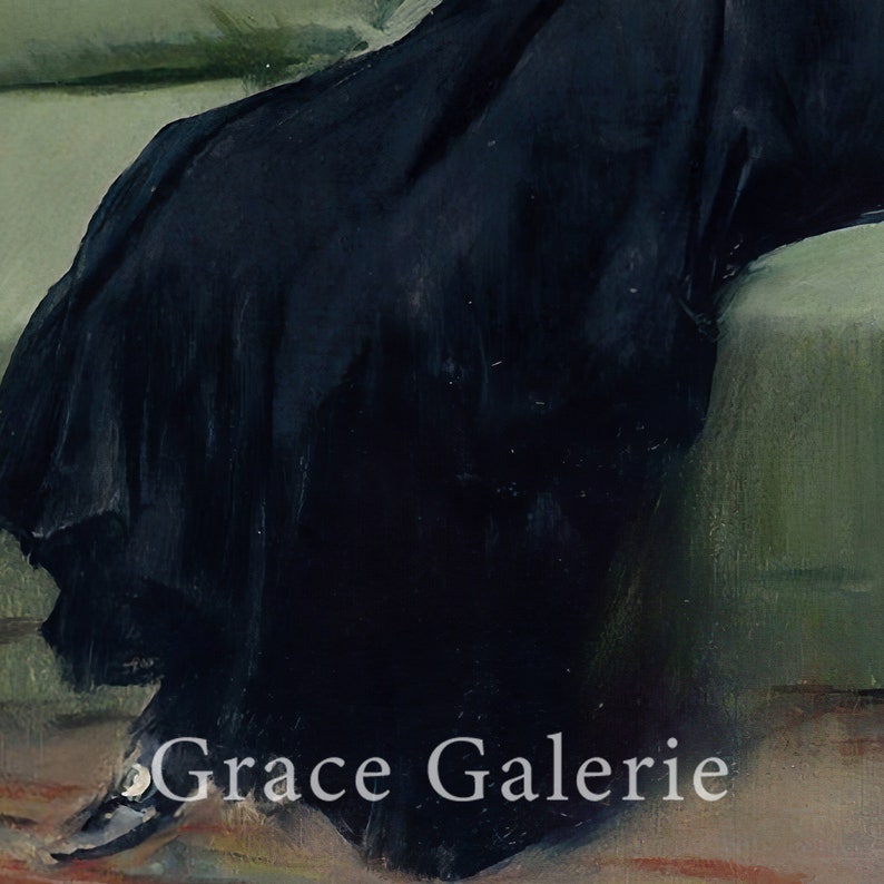 May include: A close-up of a black dress with a long skirt, the fabric is draped over a green couch. The text "Grace Galerie" is visible in the bottom right corner of the image.