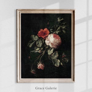 Puede incluir: Una impresi&oacute;n floral vintage enmarcada que presenta un ramo de rosas y otras flores en tonos rojos y rosas, con hojas verdes sobre un fondo oscuro. La impresi&oacute;n est&aacute; en un marco blanco desgastado. El texto "Grace Galerie" est&aacute; en la parte inferior.