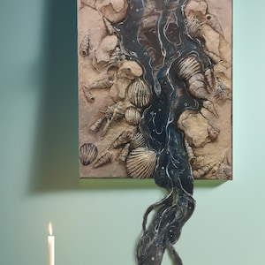 May include: A painting of a stream of water flowing through a bed of seashells. The water is dark blue and the shells are white and beige. The painting is on a canvas and has a textured surface.