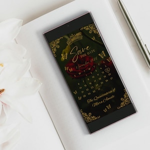 May include: A smartphone displaying a Save the Date calendar for November 2026, featuring a red rose, gold crown, and butterfly graphics. The text reads Save the Date, November 2026, and The Quinceanera of Mara Amedo, with ornate gold corners.