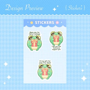 Puede incluir: Una hoja de pegatinas con ranas de dibujos animados sosteniendo regalos. Las pegatinas tienen el texto "Open me, I'm full of feelings", "I got you this emotional support gift" y "A tiny gift for your tiny chaos".