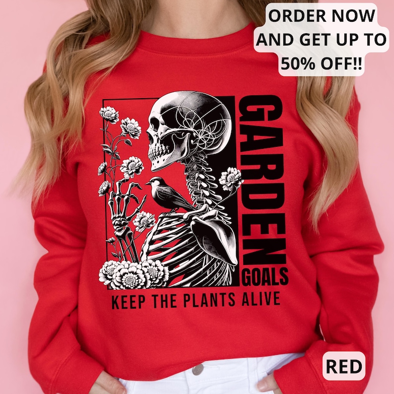 May include: Red sweatshirt with a black and white graphic of a skeleton holding flowers and a bird. The text "GARDEN GOALS KEEP THE PLANTS ALIVE" is printed on the sweatshirt.
