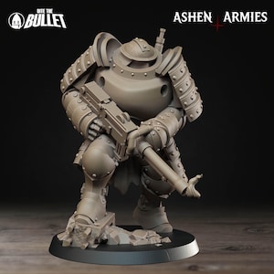 Puede incluir: Figura en miniatura gris detallada de un soldado fuertemente blindado, arrodillado y sosteniendo un rifle grande. La figura tiene un casco y cuerpo redondeados, con remaches y blindaje visibles. La base es gris oscuro, con las etiquetas "Ashen Armies" y "Bite the Bullet."