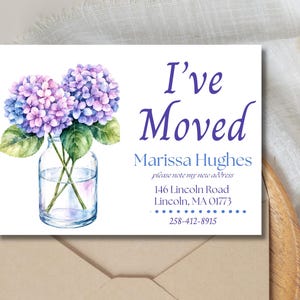 May include: A rectangular moving announcement card featuring a watercolour illustration of purple and blue hydrangea flowers in a clear glass jar. The text reads: I've Moved, Marissa Hughes, please note my new address, 146 Lincoln Road, Lincoln, MA 01773, 258-412-8915.