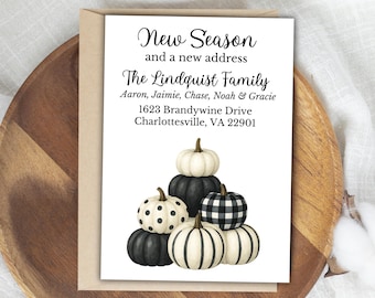 May include: A fall-themed card with the text "New Season and a new address" and "The Lindquist Family" with an address. The card features a stack of pumpkins in white, black, and a black and white checkered pattern.