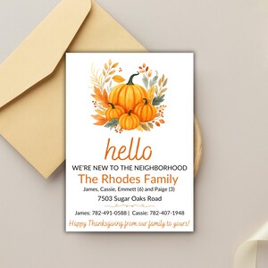 May include: Thanksgiving-themed greeting card with orange pumpkins and fall foliage. The card reads "hello" and "WE'RE NEW TO THE NEIGHBORHOOD" with The Rhodes Family's name and contact information. An envelope is in the background.