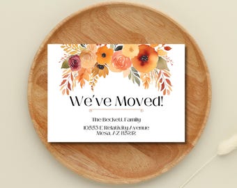 May include: A white card with a watercolour floral design in shades of orange, yellow, and red. The text "We've Moved!" is printed in black. The card includes the address "The Beckett Family, 10553 E Relativity Avenue, Mesa, AZ 85212".