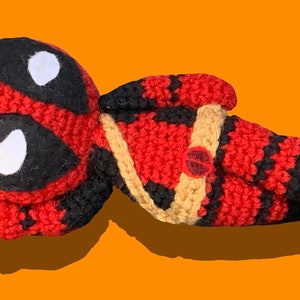 Crocheted Deadpool laying down plushie
