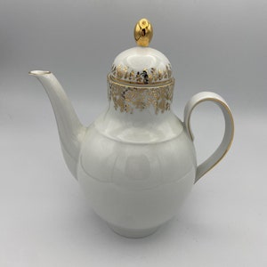May include: White porcelain teapot with a gold lid and gold floral design around the body.