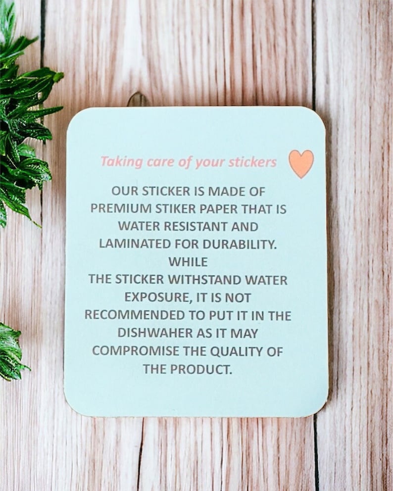 Op de afbeelding: Een lichtblauwe vierkante sticker met een roze hart in de rechterbovenhoek. De sticker heeft tekst die luidt: "Zorg voor je stickers. Onze sticker is gemaakt van premium stickerpapier dat waterbestendig is en gelamineerd voor duurzaamheid. Hoewel de sticker waterbestendig is, wordt het niet aanbevolen om hem in de vaatwasser te doen, omdat dit de kwaliteit van het product kan aantasten."