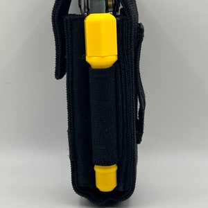 May include: A black nylon pouch with a yellow handle, designed to hold a multi-tool.