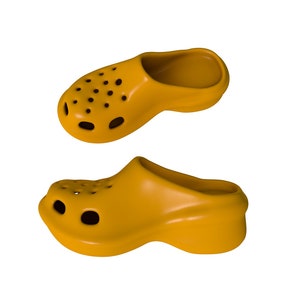 May include: Two yellow rubber clogs with holes in the top. The clogs are on a white background.