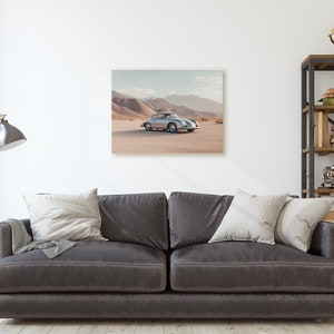 An original color car poster featuring the iconic Porsche 356 in silver in a desert. Available in  multiple sizes with free shipping. Pictured in a frame above a sofa. (frame not included)
