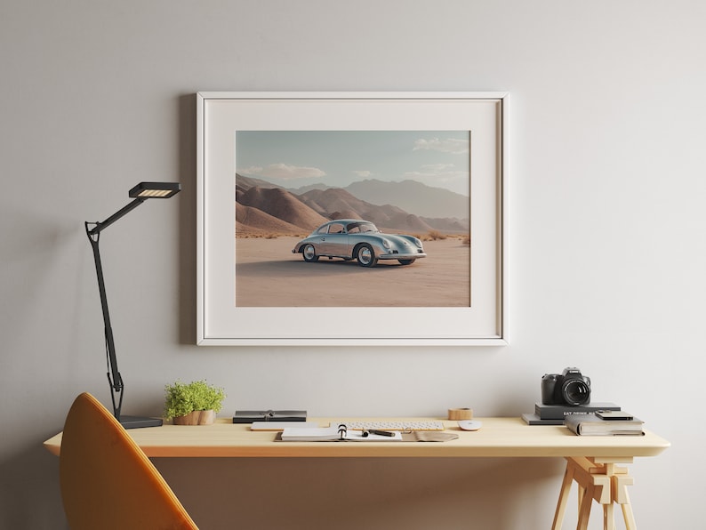 An original color car poster featuring the iconic Porsche 356 in silver in a desert. Available in  multiple sizes with free shipping. Pictured in a frame above a desk. (frame not included)