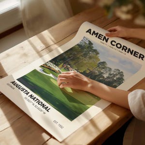 The famous Amen Corner at Augusta golf poster, great golfer gift wall art print. Showing the poster being unrolled on a light table.
