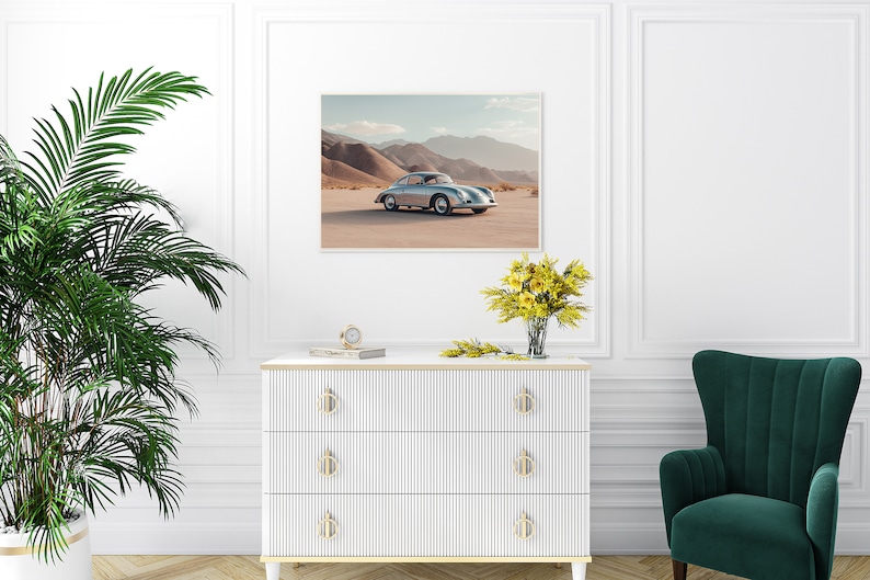 An original color car poster featuring the iconic Porsche 356 in silver in a desert. Available in  multiple sizes with free shipping. Pictured in a frame above a set of drawers. (frame not included)