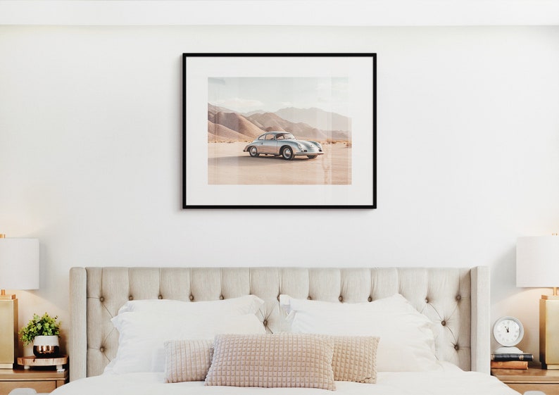 An original color car poster featuring the iconic Porsche 356 in silver in a desert. Available in  multiple sizes with free shipping. Pictured in a frame above a bed. (frame not included)