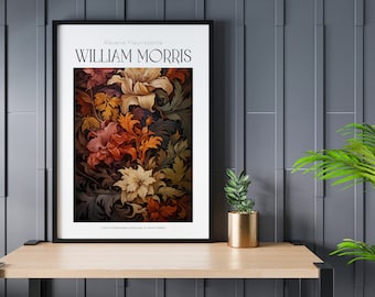 Op de afbeelding: Een ingelijste poster met een bloemenontwerp in tinten rood, oranje, geel en bruin. De poster is getiteld "William Morris" en heeft bovenaan de tekst "Rêverie Fleurisante". De poster staat op een houten tafel met een kleine plant in een pot ervoor.