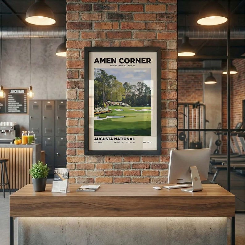 The famous Amen Corner at Augusta. This iconic golf wall art print is seen in a black frame hanging on a brick wall in a golf shop.