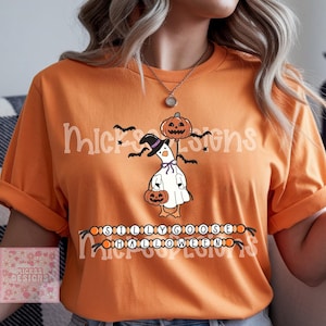 Puede incluir: Camiseta naranja con un diseño de Halloween. El diseño presenta un ganso de dibujos animados disfrazado de fantasma, sosteniendo una calabaza y usando un sombrero de bruja. El texto "SILLY GOOSE HALLOWEEN" también está impreso.