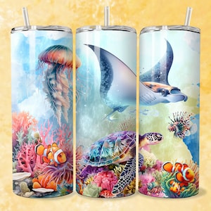 May include: Three stainless steel tumblers featuring a colourful underwater scene. The tumblers depict a sea turtle, a manta ray, a jellyfish, and clownfish swimming amongst coral reefs.