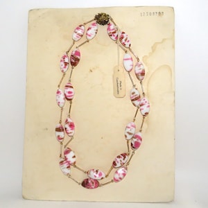 May include: A double strand necklace with pink and white oval beads with gold accents. The necklace is displayed on a white card with the text "Made in Czechoslovakia" and a number "12309703".