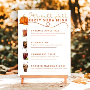 Pode incluir: Uma placa de menu branca com texto laranja escrito It's fall y'all DIRTY SODA MENU, apresentando uma ilustração de abóbora e quatro opções de bebidas: Caramel Apple Fizz, Pumpkin Pie, Cranberry Crisp e Toasted Marshmallow com ingredientes.