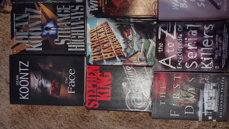 K&ouml;nnte beinhalten: Eine Sammlung von acht B&uuml;chern, die in einem Raster angeordnet sind, darunter Titel wie Strange Highways von Dean Koontz, The Regulators von Richard Bachman, The A to Z Encyclopedia of Serial Killers, The Face von Dean Koontz und The First Days von Rhiannon Frater.