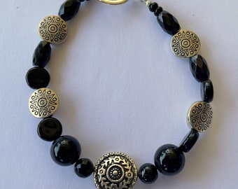 Silver toned hollow carved beads and black onyx of various shapes with modern silvery toggle 6 1/2 inches (can be enlarged).