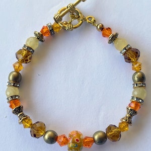 Orange, gold and topaz crystals with citrine beads, and gold toned toggle.