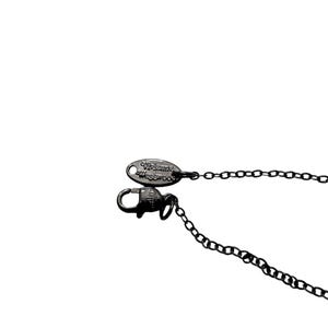 May include: A dark gunmetal-toned necklace chain featuring a lobster claw clasp and an oval-shaped metal tag engraved with the text Vivienne Westwood. The chain consists of small, uniform circular links connected to the secure fastening mechanism.