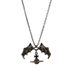 May include: A dark gunmetal-toned necklace featuring a pendant shaped like a planet with a cross on top, flanked by two bat-like wings. The wings and the central orb are encrusted with small, dark, reflective crystals, suspended from a thin chain.