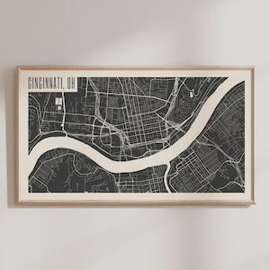 May include: Framed map print of Cincinnati, OH, in a minimalist style. The map features a black and white design with the city's layout and the Ohio River. The text "CINCINNATI, OH" is displayed at the top left corner.