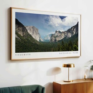 May include: A framed photograph of Yosemite National Park, featuring a panoramic view of the valley with towering granite cliffs and lush green forests. The text "Yosemite National Park" is printed below the image.